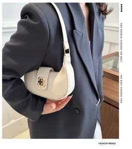 Close-up of cream crescent shoulder bag featuring vintage gold floral hardware on leather
