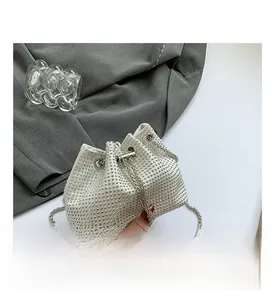Détail du sac seau argenté avec strass, bandoulière chaîne et fermeture par cordon de serrage