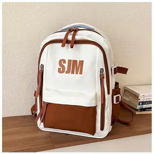 Detailansicht des Rucksacks in Creme und Braun mit SJM-Aufdruck und Reißverschluss