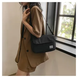 Detail einer minimalistischen schwarzen Kuriertasche mit verstellbarem Schultergurt
