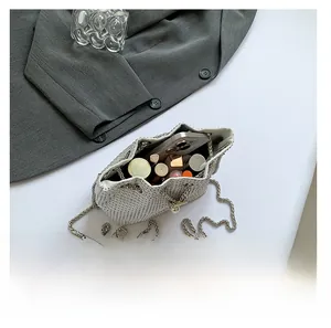 Vue de dessus du sac seau en strass argenté montrant l'espace pour téléphone et maquillage