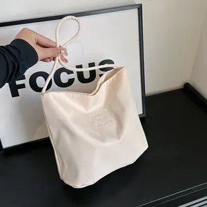 Fashionable beige nylon tote bag with embroidery and round handles for daily use