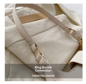Detail showing high-quality gold ring buckle connection and beige leather texture