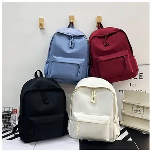 Détail de quatre sacs à dos en nylon colorés avec zips tissés et grandes poches avant