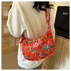 Dettaglio della borsa hobo in nylon rosso con motivi floreali e fenice tradizionali