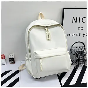 Détail d'un sac à dos blanc en nylon avec grande poche avant et tirettes en corde tressée