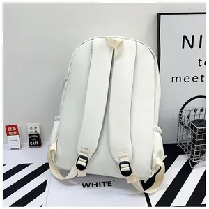 Détail des bretelles rembourrées et de la poche latérale sur ce sac à dos blanc crème