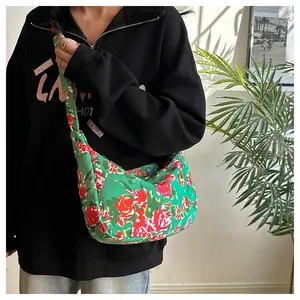 Dettaglio della borsa hobo in nylon con vivaci rose rosse su uno sfondo verde acceso