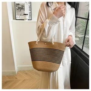 Détail du sac cabas en paille tissé main avec rayures noires et poignées en corde de coton