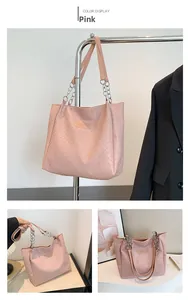 Detail view of pink woven leather tote bag with silver chain strap and fashion logo