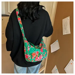 Vista dettagliata di una borsa a tracolla in nylon verde a fiori indossata da una modella