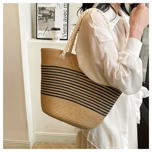 Détail d'un sac cabas en paille tressé avec rayures noires et poignées en corde