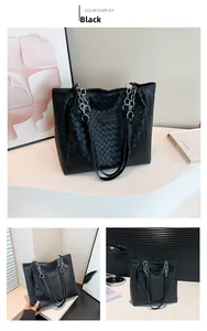 Close-up of black woven leather tote bag with silver chain strap and fashion label
