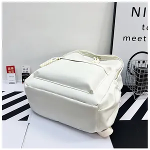 Détail d'un sac à dos blanc minimaliste montrant la texture en cuir PU et le curseur