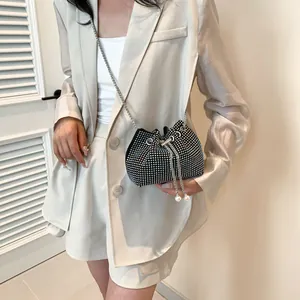 Sac seau noir avec strass scintillants, bandoulière chaîne argentée et perles sur modèle