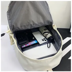 Vue intérieure montrant les compartiments spacieux du sac à dos beige minimaliste