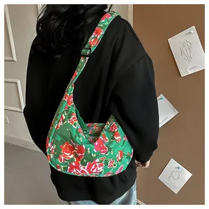 Dettaglio della borsa a mezzaluna in nylon floreale con tracolla regolabile e rose