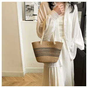Détail d'un sac cabas en paille tissé à la main avec rayures noires et anses en coton