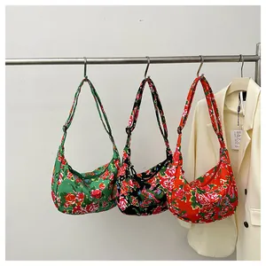 Tre borse a mezzaluna in nylon a fiori rossi, verdi e neri con tracolle regolabili