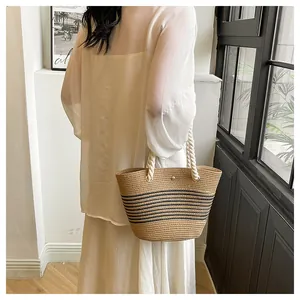 Détail du sac en paille tissé main avec rayures noires et poignées en corde de coton