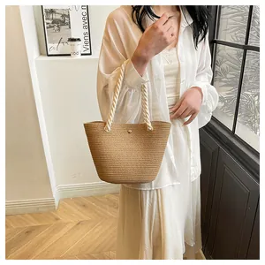 Détail du sac en paille tissé main avec poignées en corde épaisse et anneaux en métal