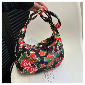 Dettaglio della borsa a mezzaluna in nylon con motivi cinesi di peonia rossa e drago