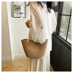 Détail du sac cabas en paille tissé à la main avec anses en corde blanche et anneaux