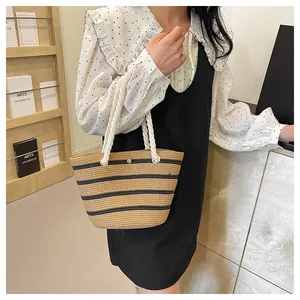 Détail du sac cabas en paille tissé à rayures noires et poignées en corde