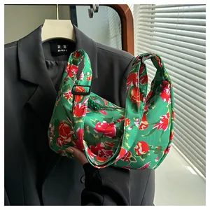 Dettaglio borsa in nylon verde con motivi floreali di peonie rosse e decorazione a nodo