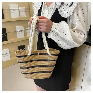 Détail d'un sac cabas en paille tissé main avec rayures noires et anses en corde