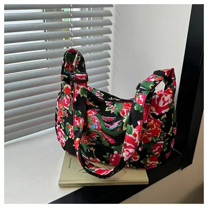 Dettaglio della fibbia regolabile e del motivo floreale in nylon della borsa a tracolla