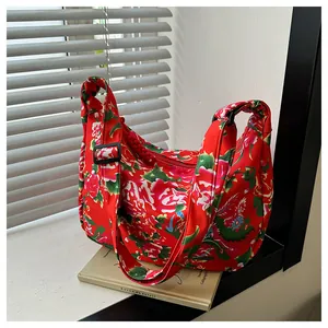 Dettaglio della borsa hobo in nylon con motivi tradizionali di peonie rosse e draghi