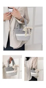 Detail of hand-woven cotton basket bag with lace bow and stylish grey-white pattern