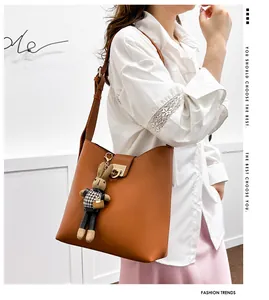 Détail du sac seau marron caramel avec boucle dorée et pendentif lapin décoratif