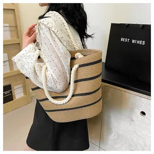 Détail du sac cabas en paille tissé avec rayures noires et poignées en corde blanche