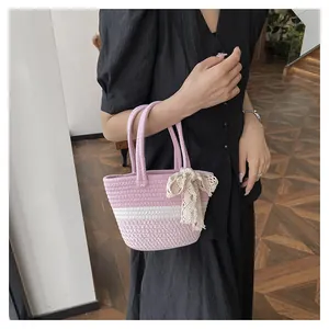Detail of hand-woven tote bag with pink and white stripes and lace bow decoration