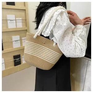 Détail du sac cabas en paille tissé main avec anses en corde et rayures blanches