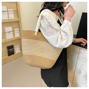 Détail d'un sac cabas en paille tissé main avec rayures blanches et anses en corde