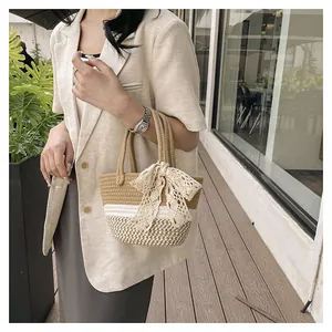 Detail of hand-woven straw tote bag with lace bow and stylish houndstooth pattern texture