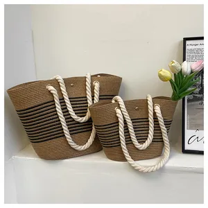 Détail de sacs en paille de deux tailles avec poignées en corde et rayures