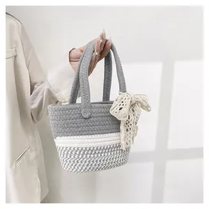 Detailed macro view of woven handbag featuring gray white patterns and a lace bow detail