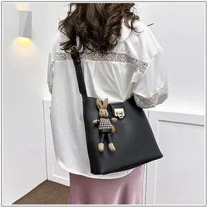 Détail de vue arrière d'un sac seau en cuir noir avec fermoir doré et pendentif lapin
