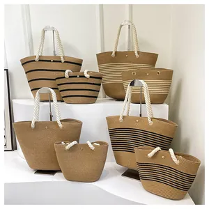 Détail de sacs de plage en paille tressée avec rayures et poignées en coton
