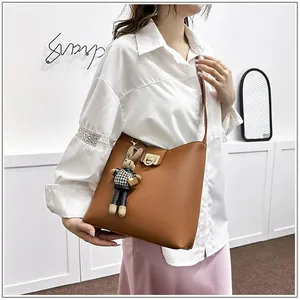 Détail du sac seau en cuir caramel avec fermoir doré et charmant lapin suspendu