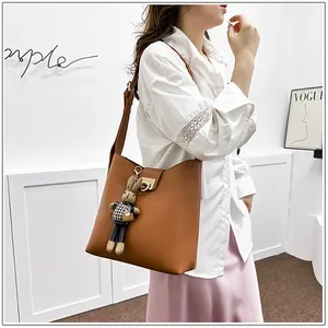 Vue détaillée du sac seau en cuir marron avec boucle en fer à cheval et breloque lapin