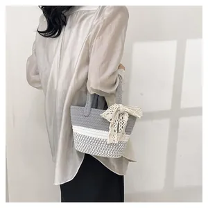 Detail of hand-woven grey cotton tote bag featuring white lace bow and houndstooth pattern