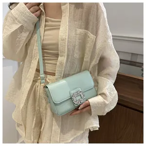 Detail of mint green crossbody bag featuring a sparkling rhinestone square buckle closure