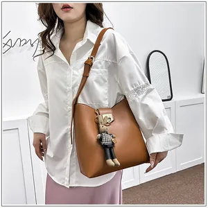 Détail du sac seau en cuir marron avec boucle en métal et breloque lapin mignonne