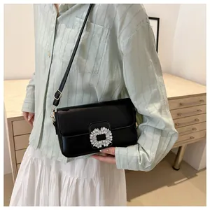 Elegant black leather square crossbody bag with luxury crystal buckle on a model