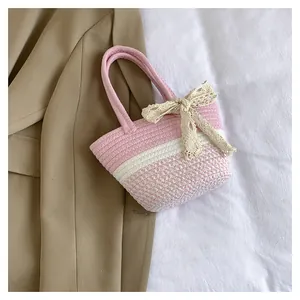 Close-up of pink and white striped woven tote bag with a large lace bow decoration